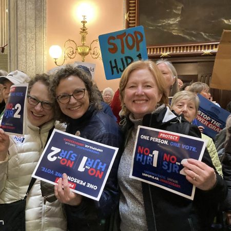 women hold signs