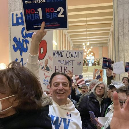 people hold protest signs